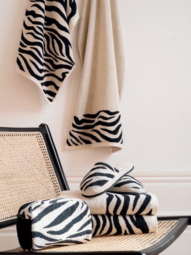 Toallas y mantas de diseño a rayas en blanco y negro sobre una silla.