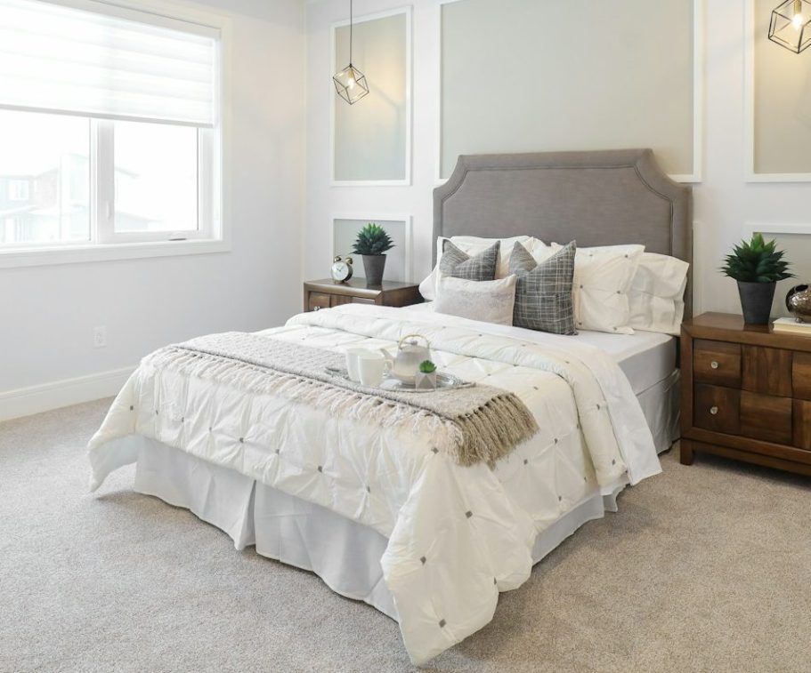 Toallas de diferentes colores y texturas colgadas en un perchero blanco.