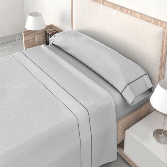 Cama con sábanas grises y lámparas blancas en una habitación moderna.