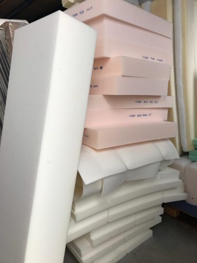 Bloques de espuma de diferentes grosores y colores apilados en un entorno de trabajo.