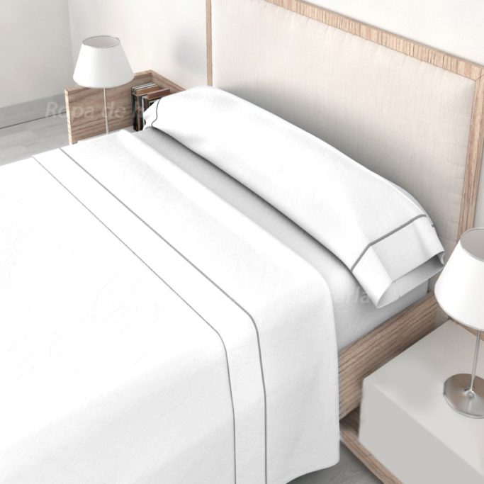 Cama con sábanas blancas y almohadas, decorada con lámparas modernas.