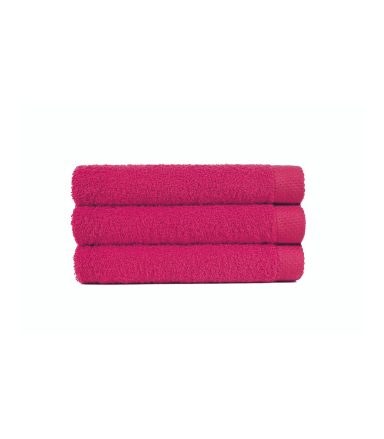 Tres toallas apiladas de color fucsia sobre un fondo blanco.