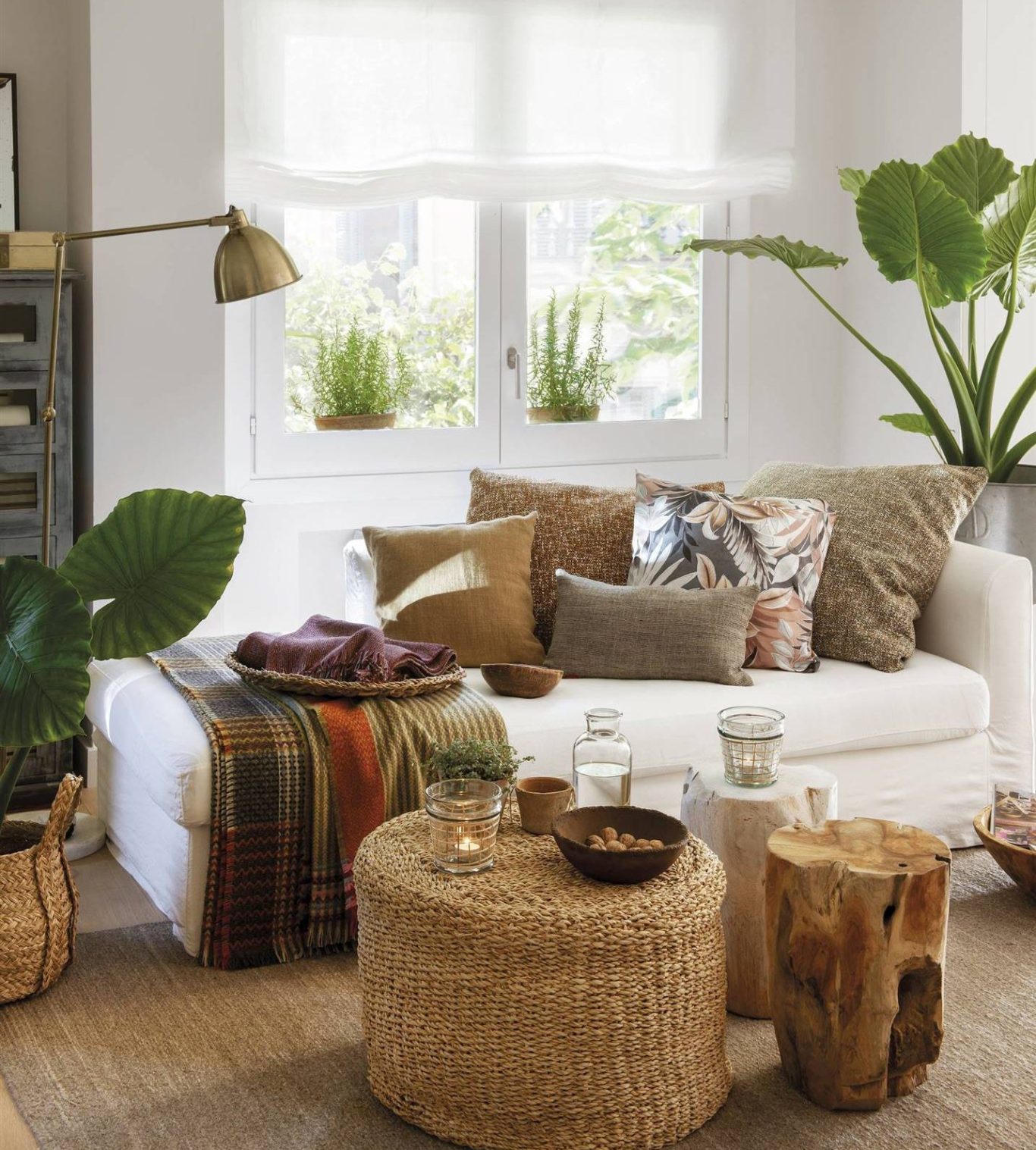 Salón moderno con sofá amarillo, cojines grises, plantas y decoración minimalista.