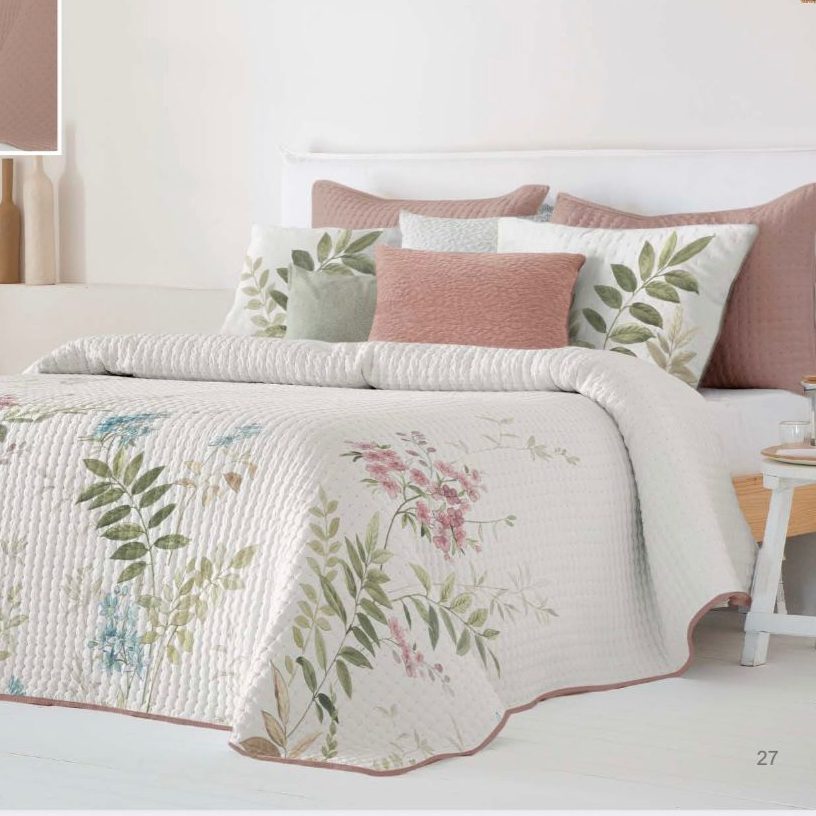 Edredón de cama blanco sobre una cama con almohadas y una mesita de noche.