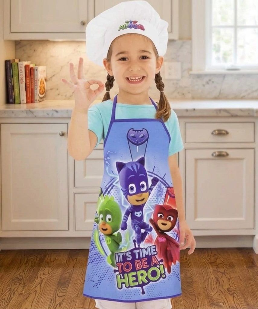 niña con delantal de dibujos y gorro
